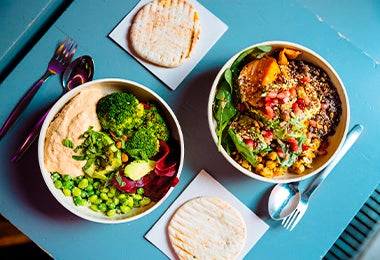 Mesa con dos platos de comida con vegetales