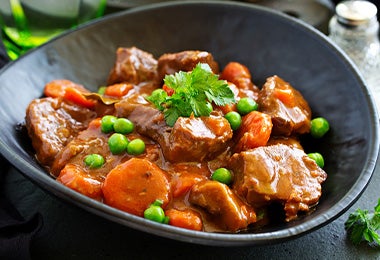 Chícharos, un alimento enlatado común, en un plato de carne.