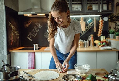 Mujer amasando amablemente la masa para los buñuelos de bacalao.