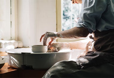 Artesano formando con arcilla comal de barro. 