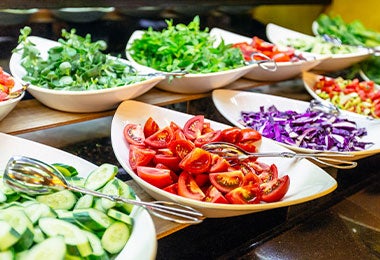 Barra de ensalada con tomate, col morada y verduras típicas de la gastronomía mexicana.