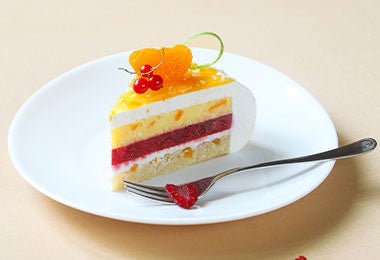 Bizcocho de mandarina con piel de limón y cerezas pequeñas.