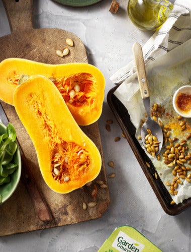 Calabaza tipo Butternut partida por la mitad, con semillas y lista para asar