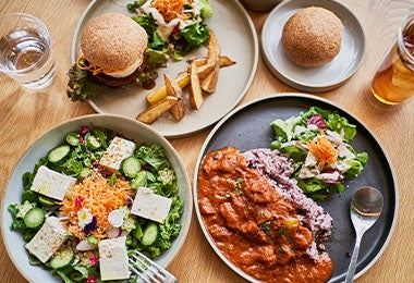 Comidas veganas, como tofu con ensalada y soya texturizada, en una mesa. 