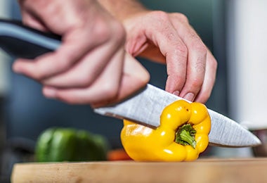 La forma correcta de agarrar un cuchillo, mientras se corta un pimentón.
