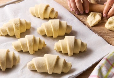 Siete croissants de almendras listos para hornear.