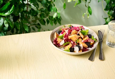 Plato con ensalada de frutas y lechuga con moras, pollo y aderezo