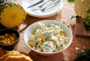 Tazón de ensalada de pollo, papa y maíz con los beneficios de la piña.