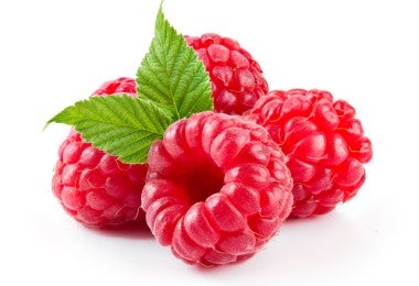 Frambuesas frescas sobre hojas, ingrediente clave para elaborar té de hojas de frambuesa