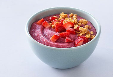 Bowl de yogurt natural de arándanos con pedazos de fresa para no inflamar el intestino.