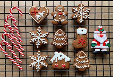 Vista desde arriba de galletas y bastones de caramelo en la rejilla de enfriamiento.