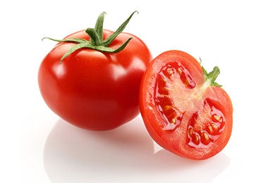 Jitomate completo y otro cortado a la mitad para hacer pipián.