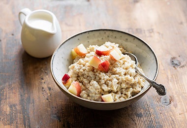 Leche y plato de porridge con manzana