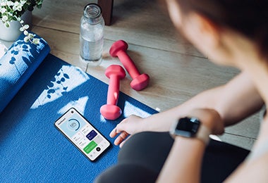 Mujer con mancuernas y mat de entrenamiento qué comer después de hacer ejercicio 