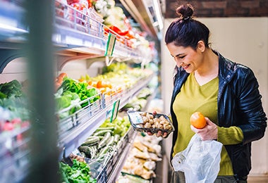 Mujer comprando champiñones y frutas supermercado clasificación alimentos