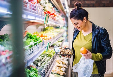 Mujer comprando champiñones y frutas supermercado clasificación alimentos   