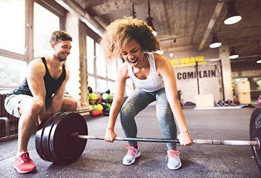 Una mujer haciendo deporte en el gimnasio en lugar de hacer ejercicio en casa