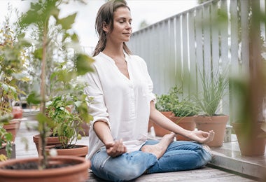 Una mujer haciendo meditación con la postura de la flor de loto