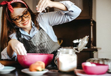 Mujer preparando arepas rellenas con harina de maíz en bowl   