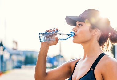 Mujer tomando agua qué comer después de hacer ejercicio