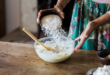 Una mujer preparando la masa de un pan sin gluten.