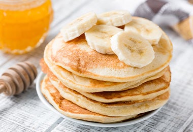 Hot cakes con banano y miel para desayuno del Día del Padre