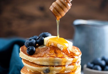 Hot cakes balanceados con miel y arándanos.