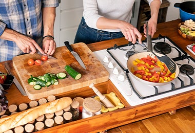 Pareja cocinando pan y vegetales contaminación cruzada 