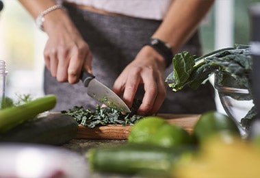 Una persona preparando el mise en place cortando con un cuchillo un ingrediente