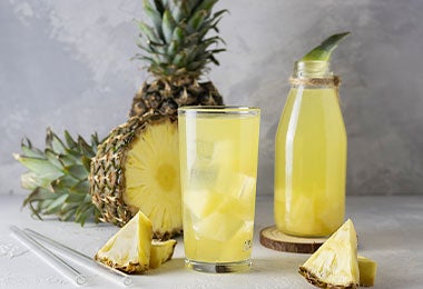 Vaso y botella de agua fresca de piña.