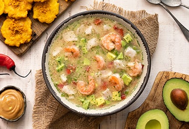 Plato de caldo de pescado con camarones, chiles, plátano y aguacate   