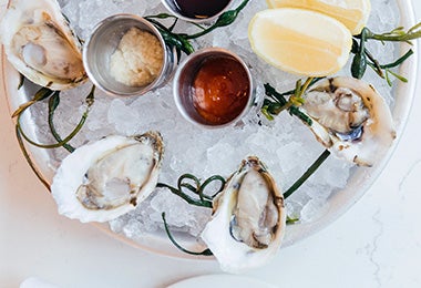 Plato de ostras con hielo y limones, consejos para comprar mariscos 