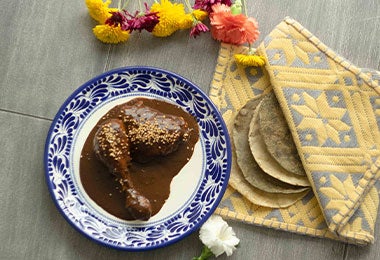 Pollo con mole oaxaqueño, decorado con semillas de ajonjolí.