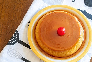 En un plato está servido un flan de caramelo decorado con una cereza es un postre sin gluten