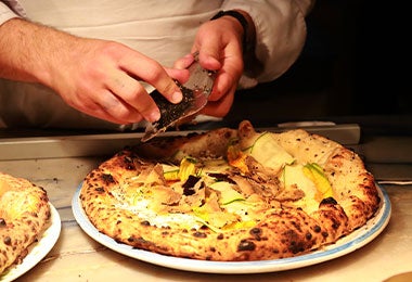 Preparación de pizza oaxaqueña con ingredientes tradicionales
