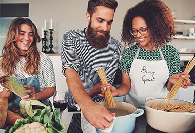 Un grupo de amigos cocinando en casa.