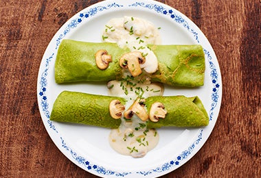 Champiñones con salsa blanca, acompañando unas crepes.