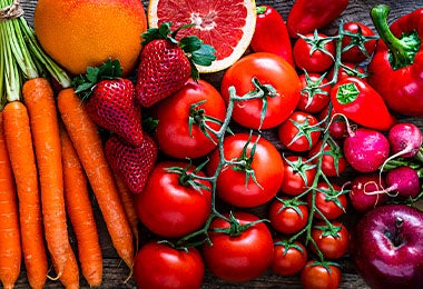 Jitomates junto a otras frutas y verduras, como zanahorias y fresas.