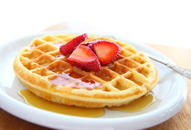 Un waffle tradicional con frutas y miel, una receta deliciosa. 