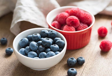 Recipientes con frambuesas y moras azules, frutos rojos