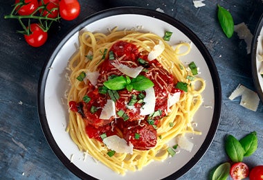 Espagueti con salsa pomodoro, queso rallado y hierbas aromáticas.