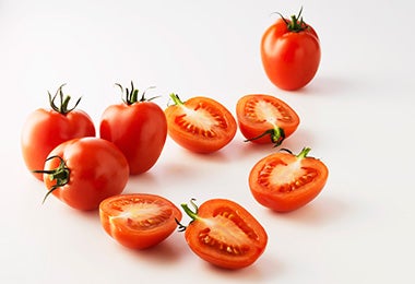 Grupo de jitomates, algunos cortados por la mitad, para usar en una salsa pomodoro.