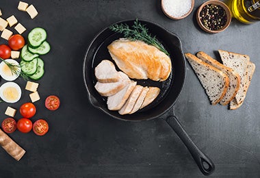 Pechuga de pollo con verduras, preparada en una sartén de hierro. 