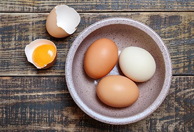 Tazón con huevos separando la yema de la clara para preparar una masa para waffles 