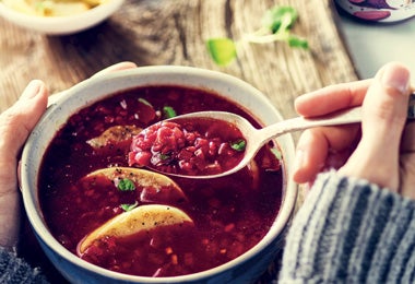 Persona consumiendo sopa caliente con bulgur y betabel