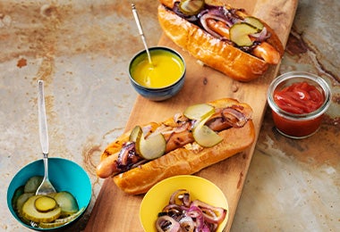 Tabla con hot dogs con salsas cátsup y mostaza  
