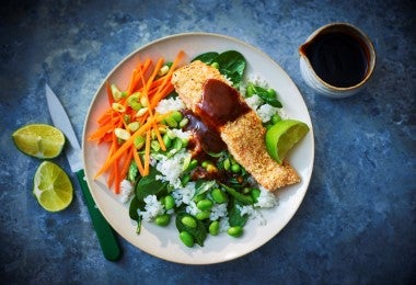 Platos con salmón al horno acompañado de arroz, vegetales y salsa