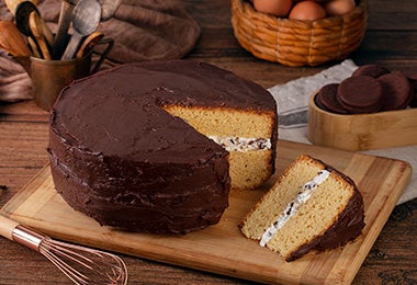 Mesa con pastel de cumpleaños de vainilla con cobertura de chocolate