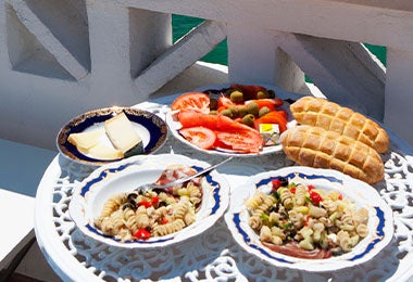 Una mesa con dos platos servidos y con vista al mar, una posibilidad del turismo gastronómico. 