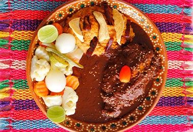 Un plato de mole con pollo y ensalada, muy famoso en el turismo gastronómico de México.